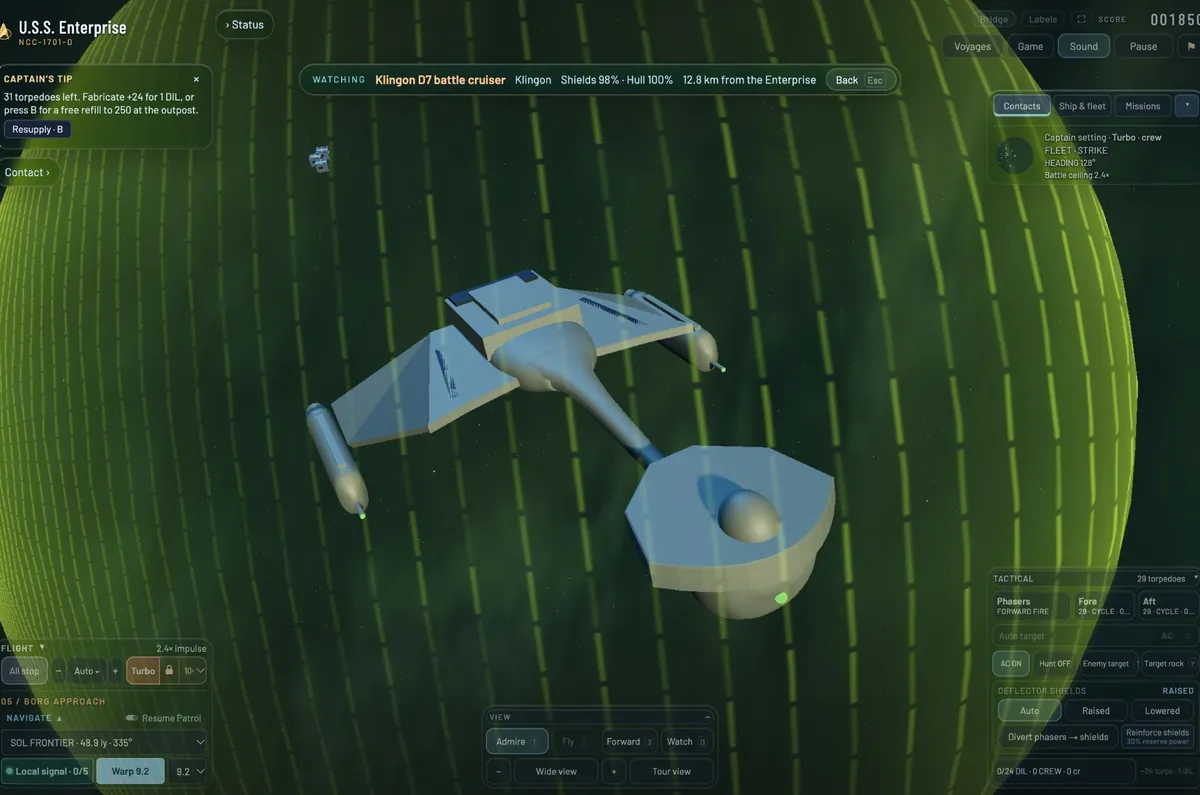 A Klingon D7 battle cruiser from above through its green shield bubble, swept wings and nacelles spread wide.