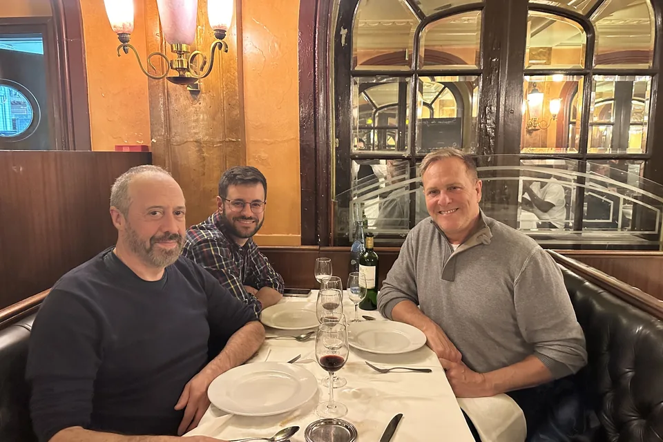 Eric with two friends at a restaurant in Paris in 2024.